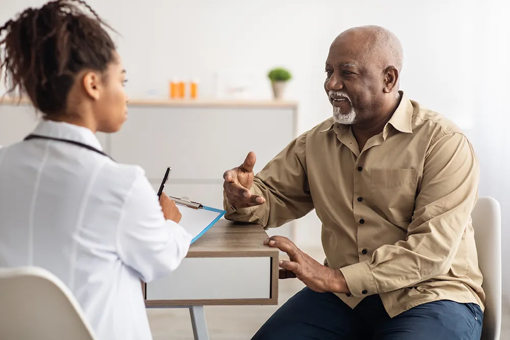 Black patient and provider talking at a clinic